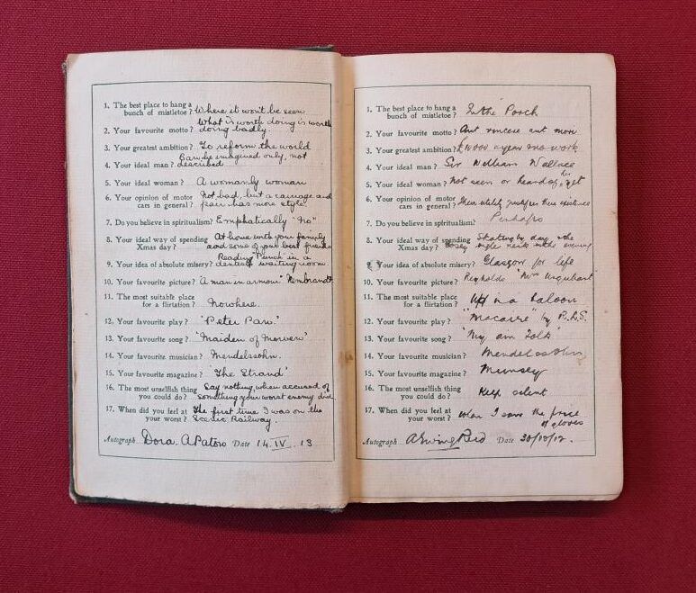 An open page of 'My confesison book.' The pages have some neat and less neat calligraphy writing, on a red background